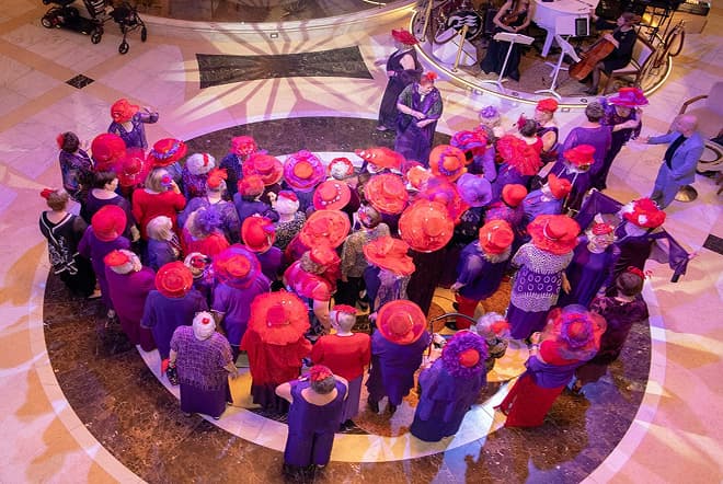 A crowd of members in red hats gathered on a cruise ship, seen from above